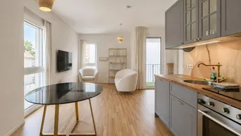 Helles, offenes Wohn-Esszimmer mit integrierter Küche, Parkettboden und Zugang zum Balkon.