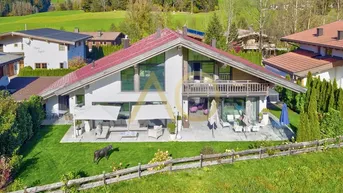 Großzügiges Einfamilienhaus mit weitläufigem Garten, sonniger Terrasse und Bergblick in idyllischer Umgebung.