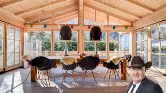 Heller Essbereich im Chalet-Stil mit Holzwänden, hohen Decken und Bergblick durch große Fenster.