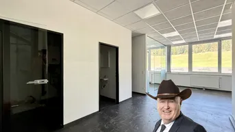 Geräumiges, helles Büro mit großen Fenstern und Blick ins Grüne, ausgestattet mit modernen Glastrennwänden.