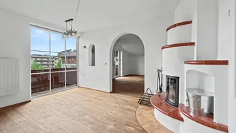 Geräumiges Wohnzimmer mit Holzboden, Kamin und Zugang zu einem Balkon mit Ausblick.