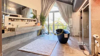 Luxuriöses Badezimmer mit freistehender Badewanne, großer Dusche und Balkonzugang.