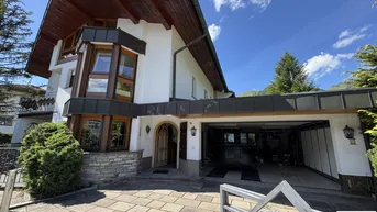 Traditionelles Haus mit Holzdetails, Steinfassade und integrierter Doppelgarage.