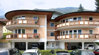 Mehrfamilienhaus mit mehreren Balkonen und Blick auf die umliegende Berglandschaft.