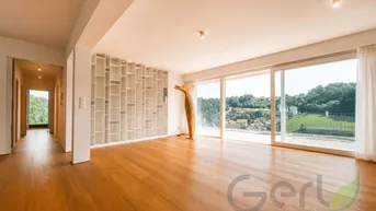 Helles Wohnzimmer mit Holzboden, großen Schiebetüren und weitem Blick ins Grüne.