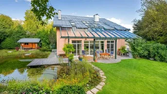 Ansicht des Hauses mit großem Garten, Teich und sonniger Terrasse.