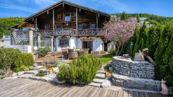 Traditionelles Chalet mit gepflegtem Garten, Terrasse und Bergblick in sonniger Lage.