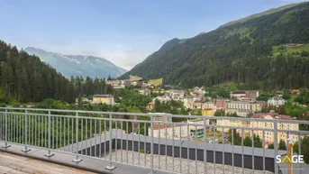 Panoramablick von einer Dachterrasse auf ein Bergdorf und die umliegende Alpenlandschaft.