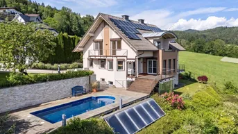 Luftaufnahme eines Hauses mit Pool, Solaranlagen auf dem Dach und weitem Blick ins Grüne.