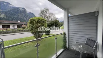 Balkon mit Sitzgelegenheiten und einem malerischen Blick auf die umliegenden Berge.