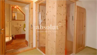 Rustikales Badezimmer mit Holzelementen und einer modernen Duschkabine, passend zum alpinen Stil.