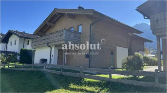 Attraktives Holzhaus im Chalet-Stil mit Balkonen und gepflegtem Vorgarten.