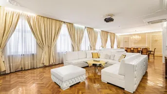 Großzügiger Wohn- und Essbereich mit elegantem Fischgrätparkett, weißen Sofas und opulenten Vorhängen.