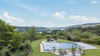 Großzügiger Gartenbereich mit Pool, Liegeflächen und atemberaubendem Weitblick über die Landschaft.