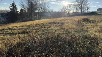 Sonniges Grundstück mit weitem Blick über die Landschaft und umliegende Bebauung.