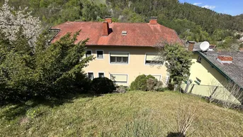 Hinteransicht des Hauses mit Gartenbereich und Blick auf eine Burg auf dem Hügel.