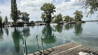 Expose große UFERPAZRELLE mit privatem Badesteg am Neufelder See – Holzhaus mit Renovierungsbedarf beim Yachtclub auf Pachtgrund zu verkaufen