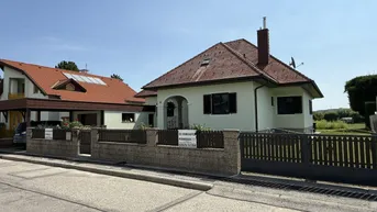 Einfamilienhaus mit gepflegtem Vorgarten und Zaun, sichtbar von der Straße aus.