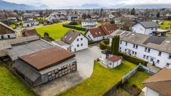 Luftaufnahme des Anwesens mit Wohnhaus, Nebengebäuden und umliegender grüner Landschaft.
