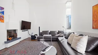 Helles Wohnzimmer mit Kamin, Holzboden und großem Ecksofa für entspannte Abende.