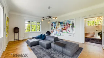 Helles Wohnzimmer mit modernem Sofa, Parkettboden und Blick ins Grüne.