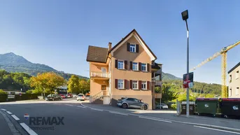 Das Gebäude steht an einer Straßenecke mit Blick auf die umliegende Berglandschaft und einen Kran im Hintergrund.