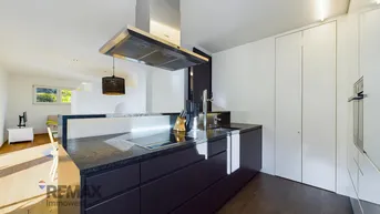 Moderne Küche mit dunklen Schränken, Granitarbeitsplatte und integriertem Induktionskochfeld.