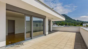 Große, sonnige Terrasse mit Fliesenboden und weitem Blick auf die umliegende Berglandschaft.