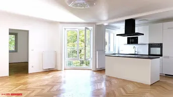 Heller offener Wohnbereich mit moderner Küche, Fischgrätparkett und Zugang zu einem französischen Balkon.