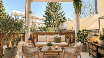 Gemütliche überdachte Terrasse mit Outdoor-Sitzgruppe und Pflanzen, ideal zum Entspannen im Freien.