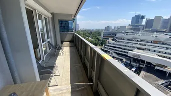 Sonniger Balkon mit Stadtblick und Platz für entspannte Stunden im Freien.