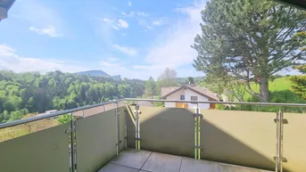 Geräumiger Balkon mit Fliesenboden und weitem Blick auf grüne Hügel und Berge.