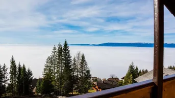 Atemberaubender Blick vom Balkon über eine dichte Nebeldecke und ferne Berge.