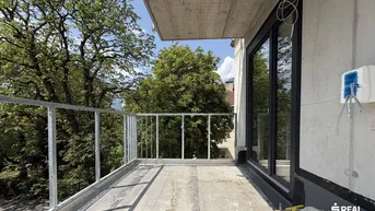 Unfertiger Balkon mit Metallgeländer und Blick ins Grüne, bereit für den weiteren Ausbau.