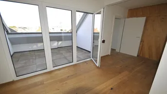 Helles Zimmer mit Holzboden und Zugang zu einer Dachterrasse, ideal für einen Wohnbereich.