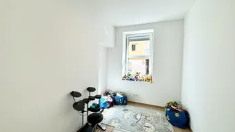 Helles Kinderzimmer oder Spielzimmer mit Holzboden und Blick ins Grüne.