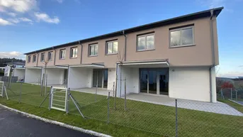 Reihenhäuser mit moderner Architektur, kleinen Gärten und Terrassen im Neubaugebiet.