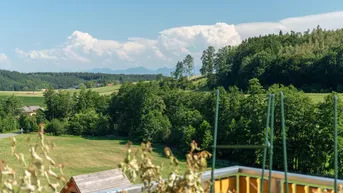Malerischer Ausblick vom Balkon über grüne Hügel, Wälder und die weite Landschaft.