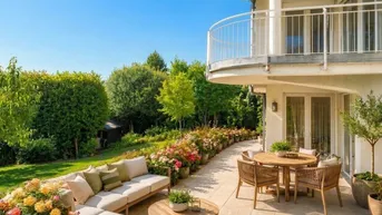 Große, möblierte Terrasse mit bequemen Sitzgelegenheiten und blühenden Blumenbeeten im Garten.
