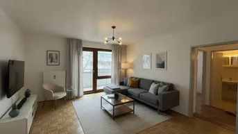 Helles Wohnzimmer mit modernem Sofa, Parkettboden und Zugang zum Balkon.