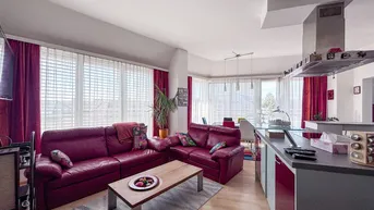 Offener Wohnbereich mit roten Sofas, Essbereich und integrierter Küche, hell und modern.