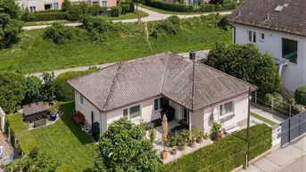 Luftaufnahme des Einfamilienhauses mit großem Garten, Terrasse und umliegender Wohnbebauung.