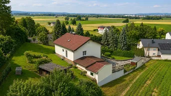 Luftaufnahme eines Einfamilienhauses mit großem Garten und weitem Blick über die ländliche Umgebung.
