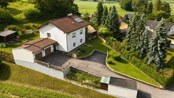 Vogelperspektive des Hauses mit Zufahrt, Garage und gepflegtem Gartenbereich in ländlicher Lage.