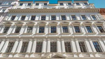 Eindrucksvolle weiße Fassade eines historischen Gebäudes mit vielen Fenstern und klassischer Architektur.