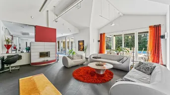 Modernes Wohnzimmer mit Kamin, dunklen Fliesen und Zugang zum Außenbereich mit Pool.