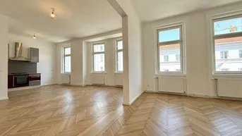 Geräumiger offener Wohnbereich mit Fischgrätparkett und Blick auf die Stadt.