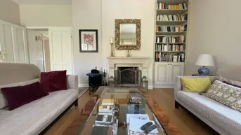 Elegantes Wohnzimmer mit Kamin, Einbauregal und bequemen Sofas, ideal zum Entspannen.