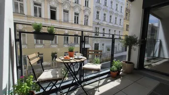 Gemütlicher Balkon mit Sitzgelegenheiten und Pflanzen, bietet einen Blick auf die Stadtstraße.