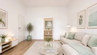 Helles Wohnzimmer mit modernem Sofa, Holzboden und offenem Zugang zum Essbereich.